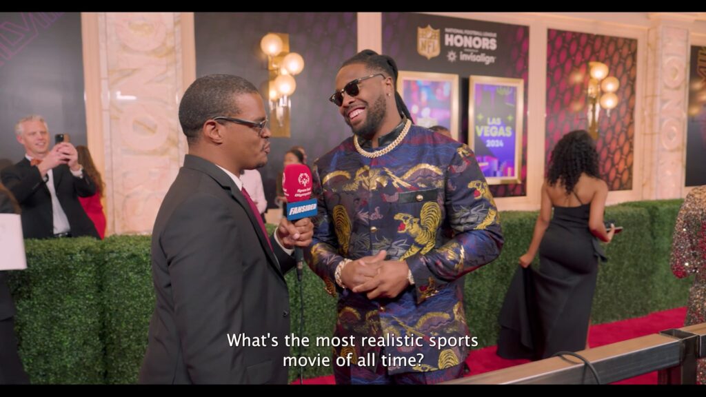 a football player is getting interviewed on a red carpet