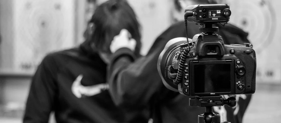 A videographer talking to a client behind the camera