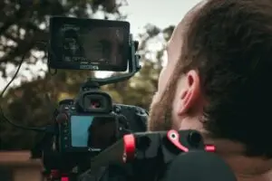 A videographer focusing on the shot for the outdoor commercial