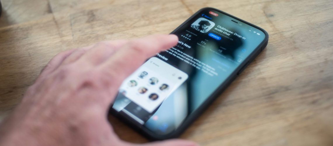 A hand grabbing a mobile device to use social media