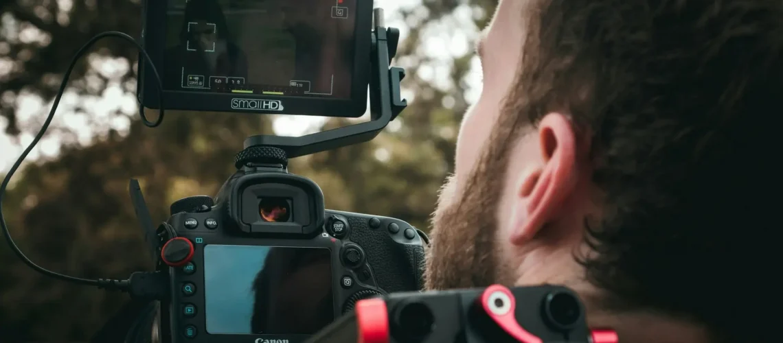 A videographer focusing on the shot for the outdoor commercial