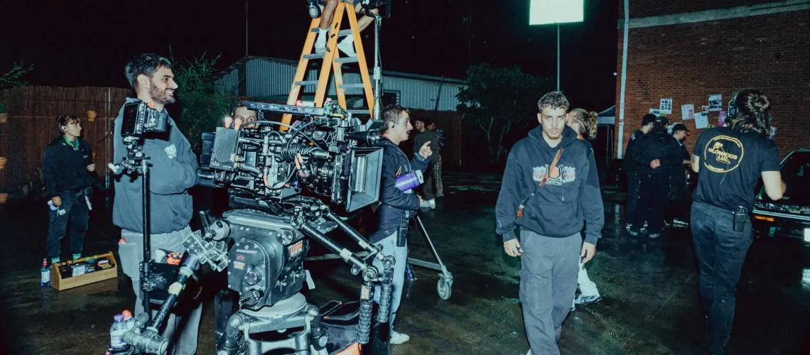 A music video production crew setting up in the location