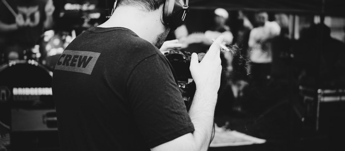 A man wearing a shirt with "crew" printed on the back