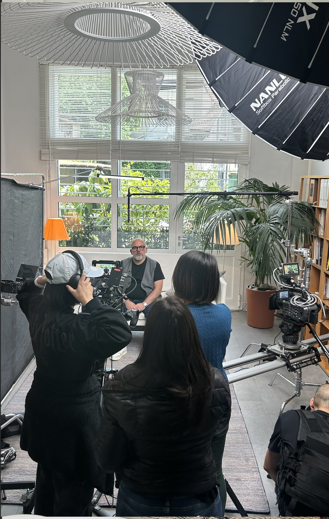 professional interview setup, a man is seated giving an interview while film crew behind camera is conducting the interview