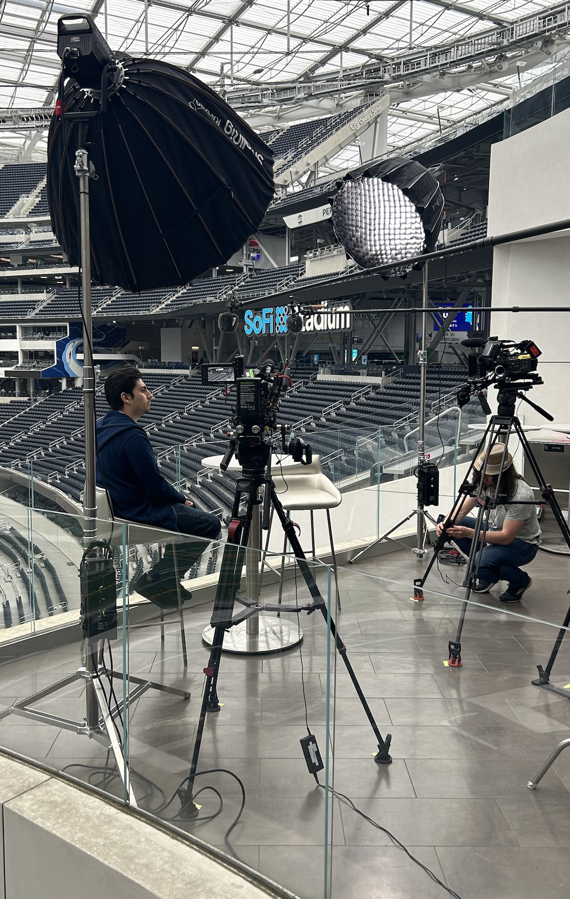 an interview setups with couple of cameras and lighting with sofboxes inside a SOFI Stadium in Los Angeles