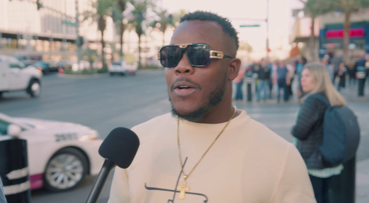 an African American male wearing sunglasses is getting interviewed on the Las Vegas strip