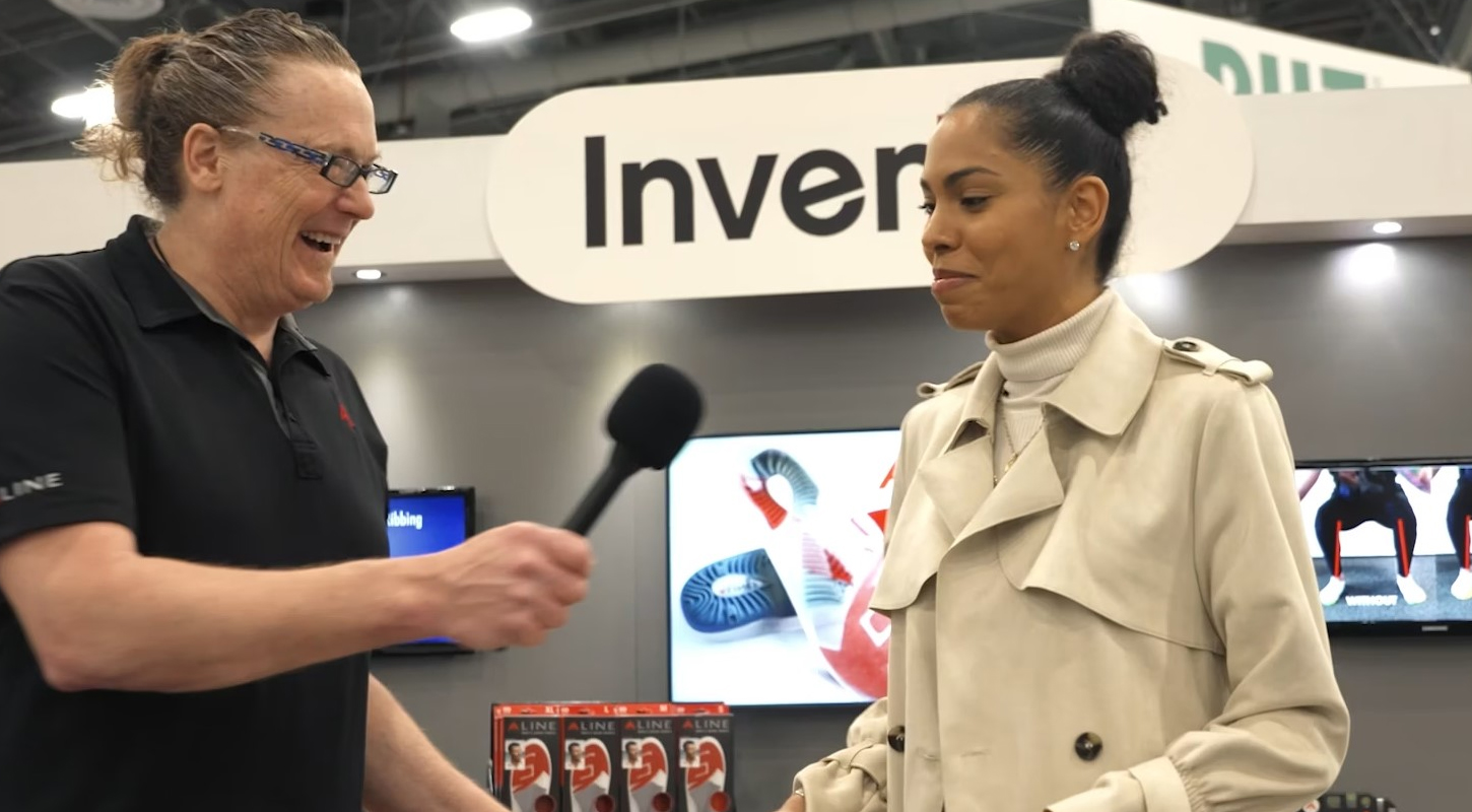 an African American woman is getting interviewed by a white male , he is smiling