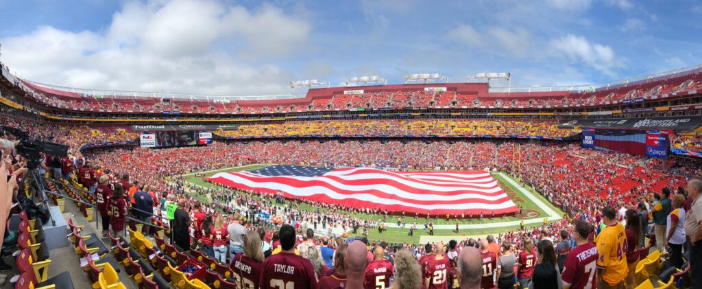 The American flag spread wide on the field before the NFL games