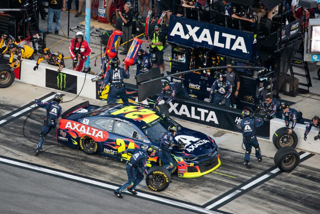 Team for NASCAR race rushing to change the tires and oil of the car