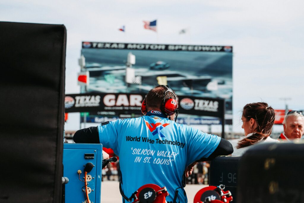 A staff listening and coaching the driver in the race