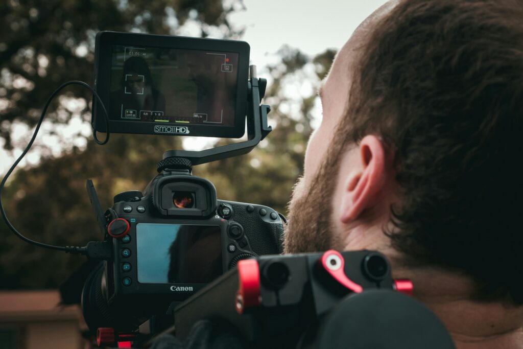 A videographer focusing on the shot for the outdoor commercial