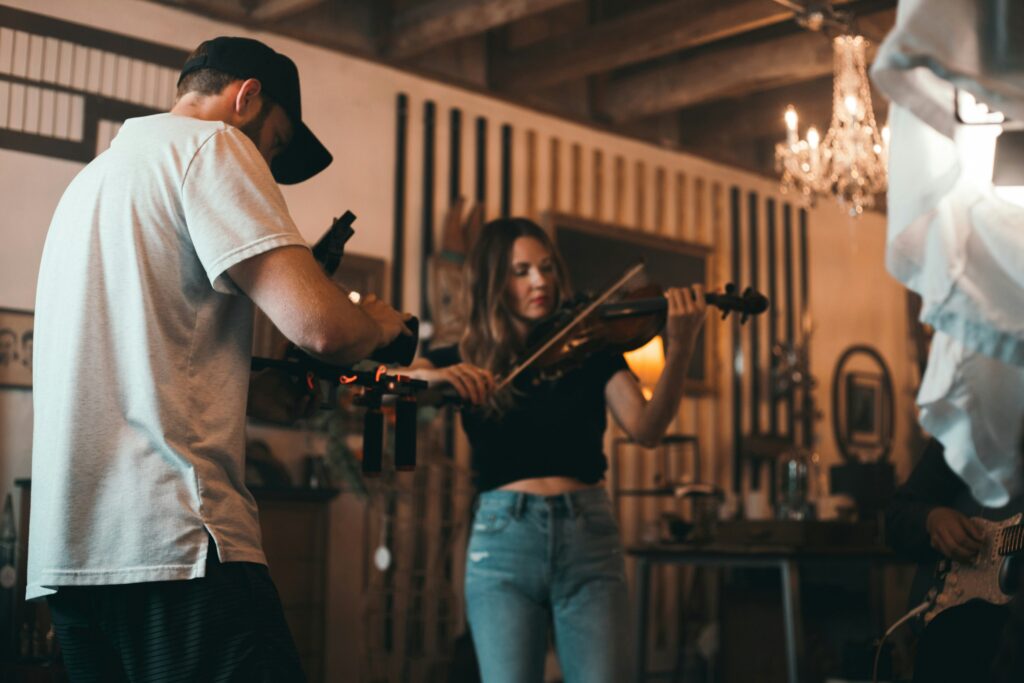 A woman music artist playing violin captured by HUSTL Media