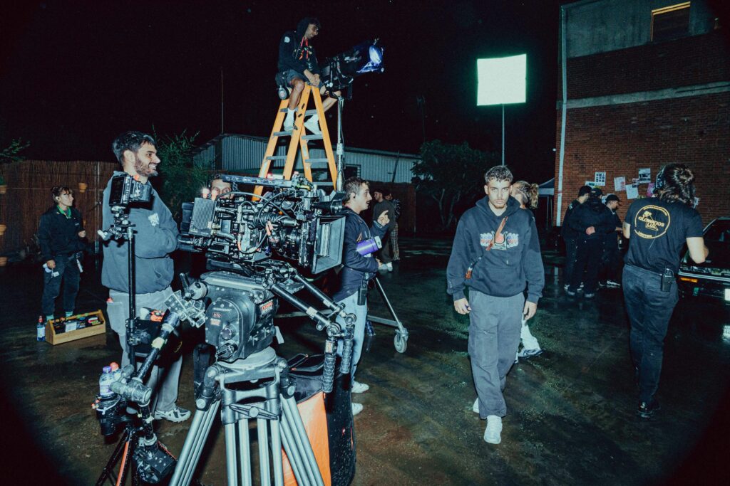 A music video production crew setting up in the location