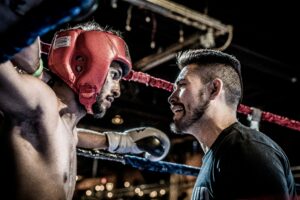 UFC fighter talking to his coach before the next round of the fight