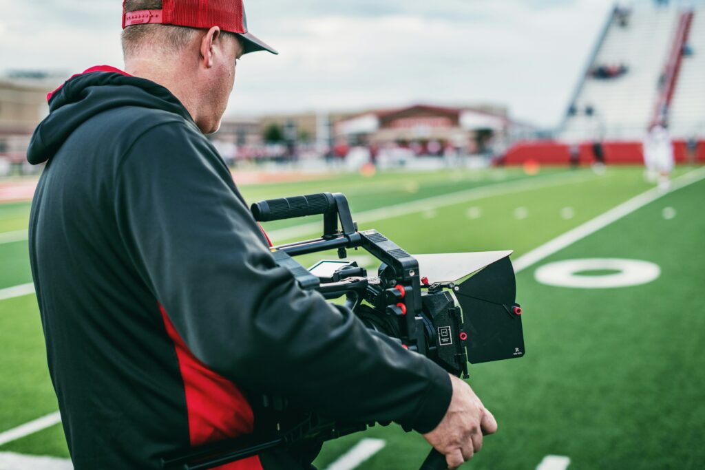 A man holding a camera shooting a sports event