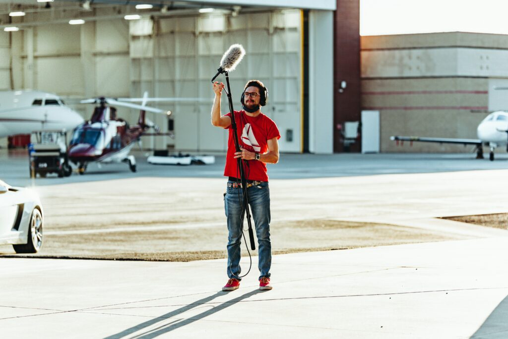 A camera crew holding a tall microphone for video testimonial