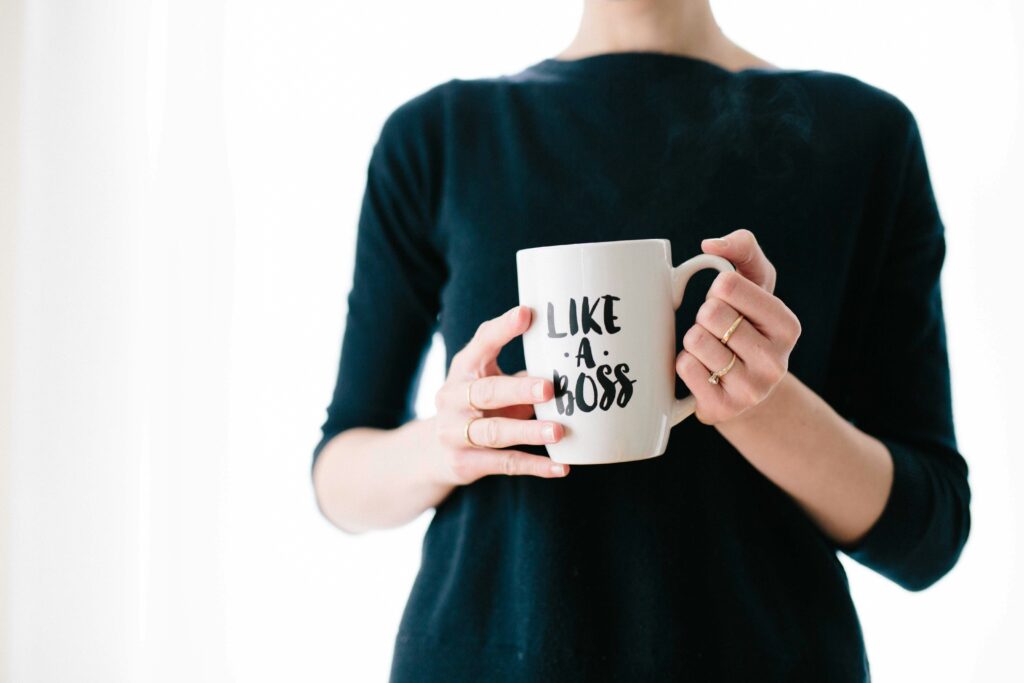 A woman carrying a mug that says like a boss